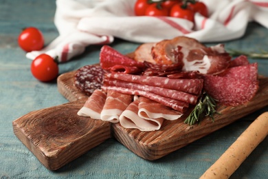 Cutting board with different sliced meat products served on table