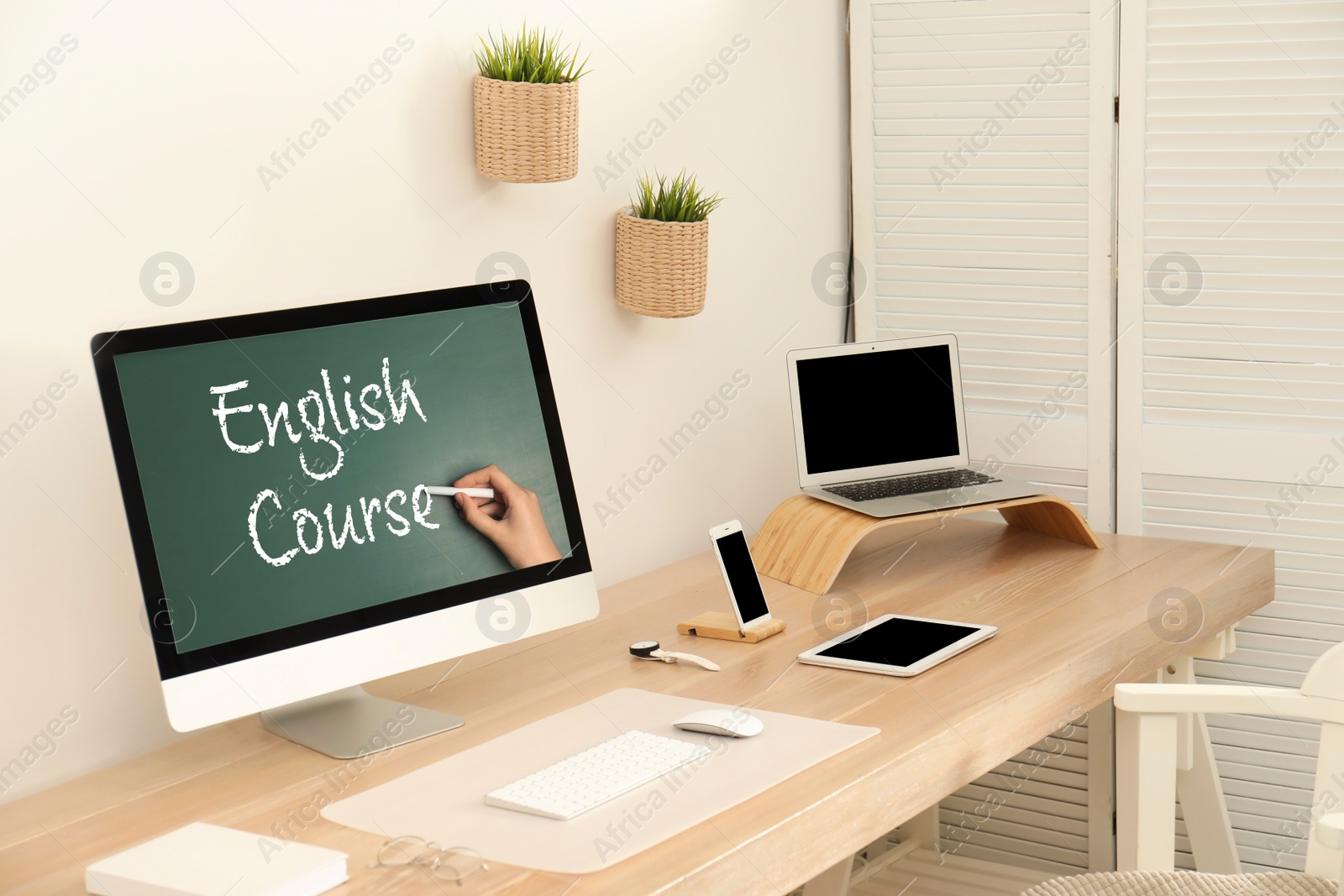 Image of Modern computer for online English learning with teacher on table indoors