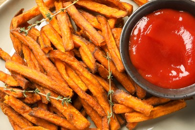 Sweet tasty potato fries and ketchup on plate, closeup