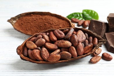 Photo of Cocoa pods of beans and powder on white table