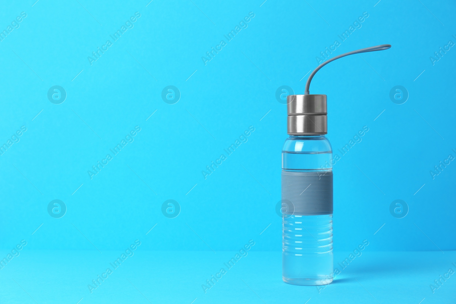 Photo of Transparent sport bottle with water and space for text on color background