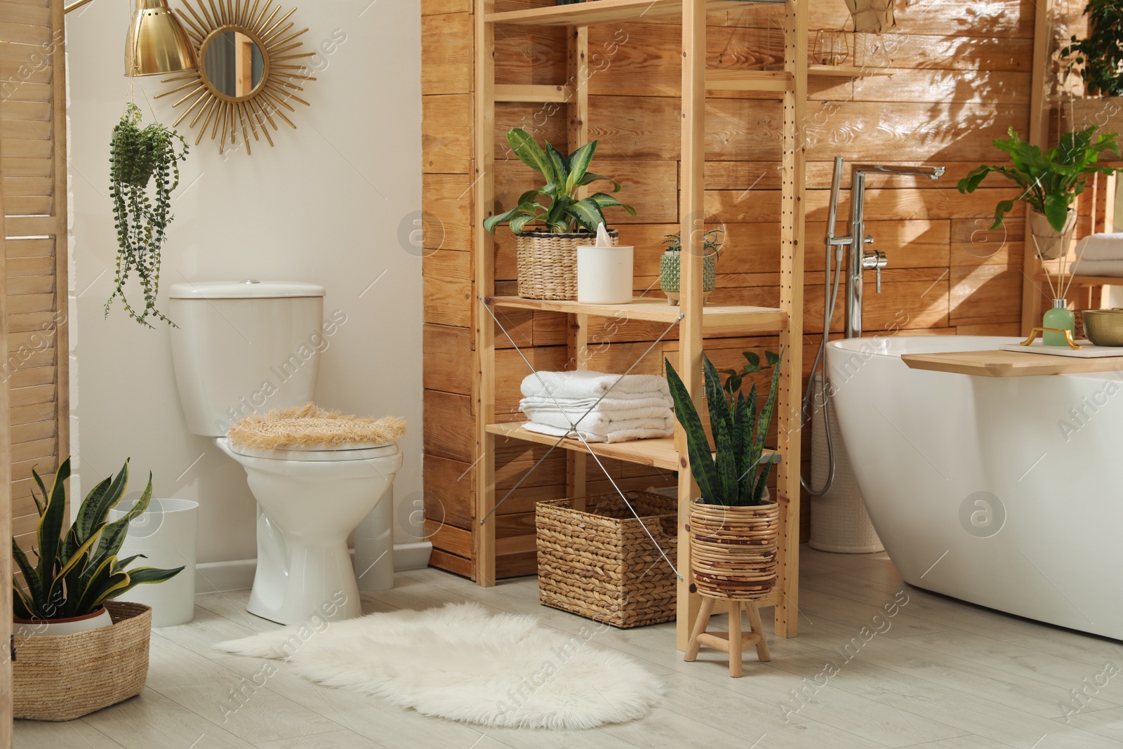 Photo of Stylish bathroom interior with white tub and green houseplants near wooden wall. Idea for design