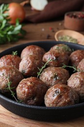 Photo of Tasty cooked meatballs served on wooden board, closeup