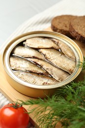 Photo of Canned sprats, dill and tomato on table, closeup