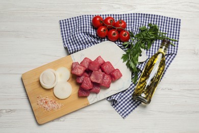 Raw beef meat and different ingredients for cooking delicious goulash on white wooden table, flat lay