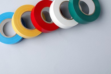 Photo of Colorful insulating tapes on white background, flat lay. Space for text