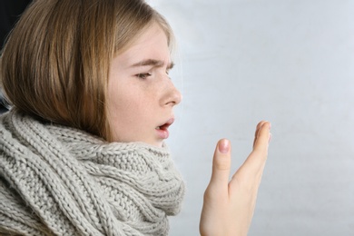 Photo of Teenage girl suffering from cough isolated on white