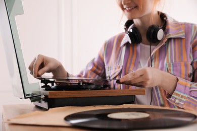 Young woman using turntable at home, closeup