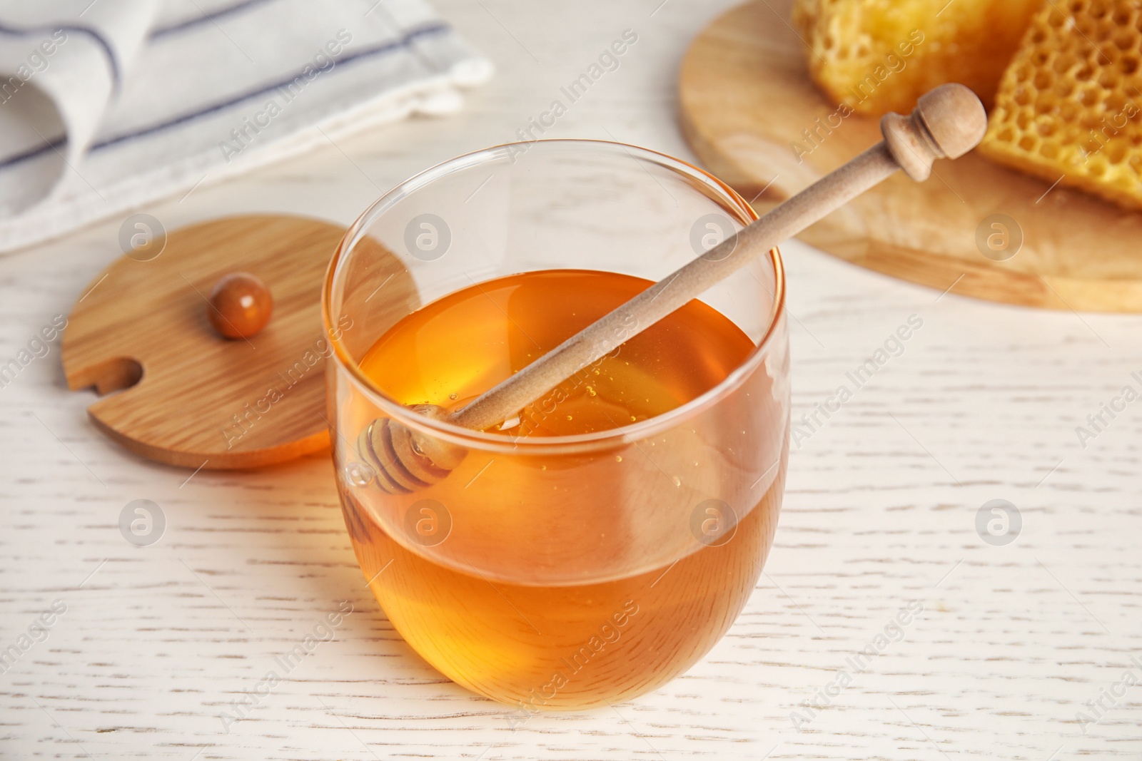 Photo of Glass jar of honey on white wooden table