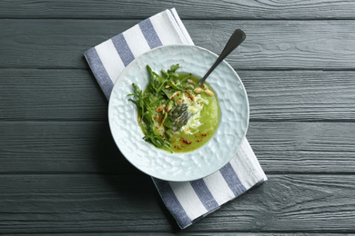 Delicious asparagus soup served on grey wooden table, top view