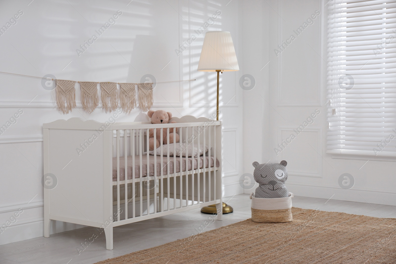 Photo of Cute baby room interior with comfortable crib and teddy bear