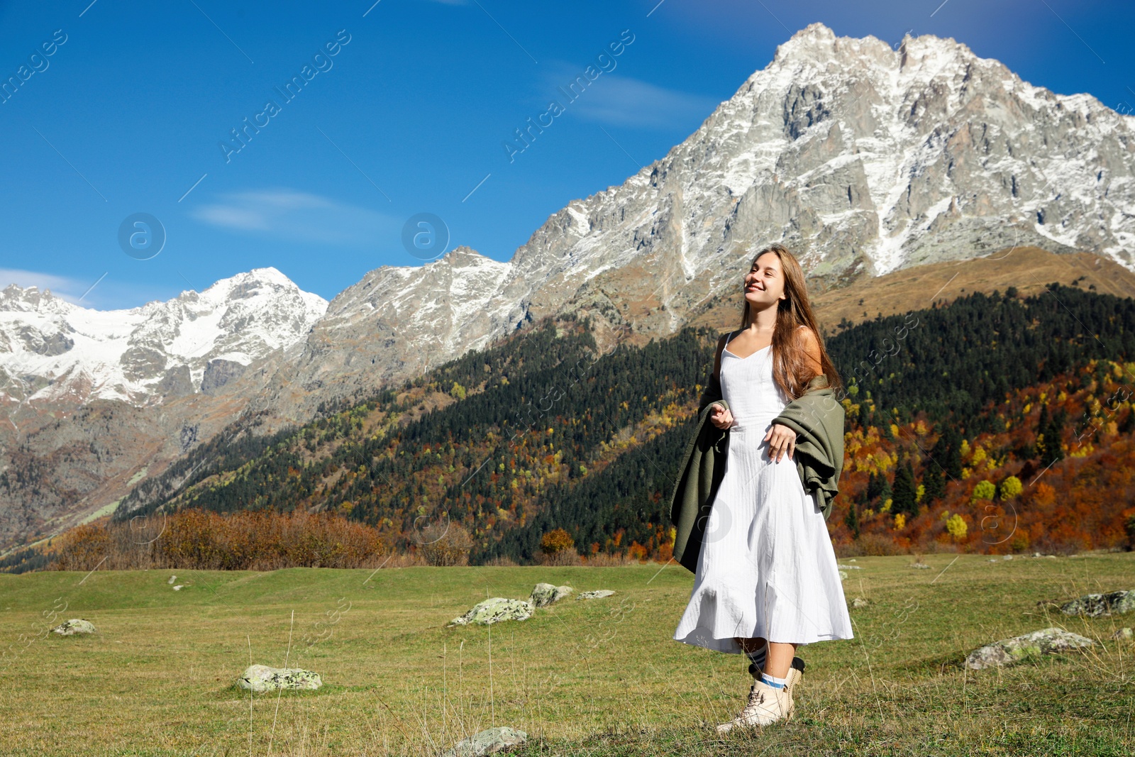 Photo of Young woman walking in beautiful mountains on sunny day