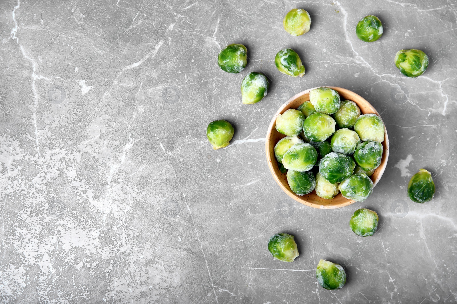 Photo of Flat lay composition with frozen brussel sprouts on grey background. Vegetable preservation
