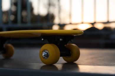 Photo of Modern yellow skateboard on top of ramp outdoors, closeup