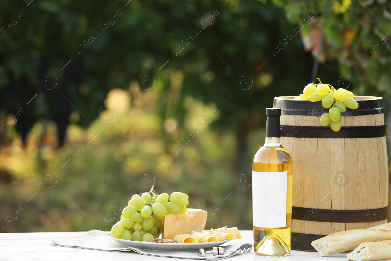 Photo of Composition with bottle of wine and snacks on table at vineyard