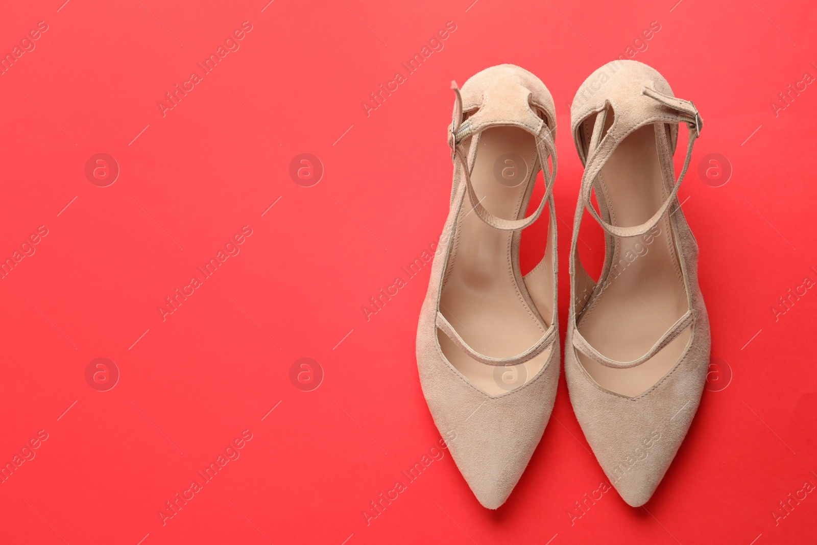 Photo of Stylish high heeled shoes on red background, top view. Space for text