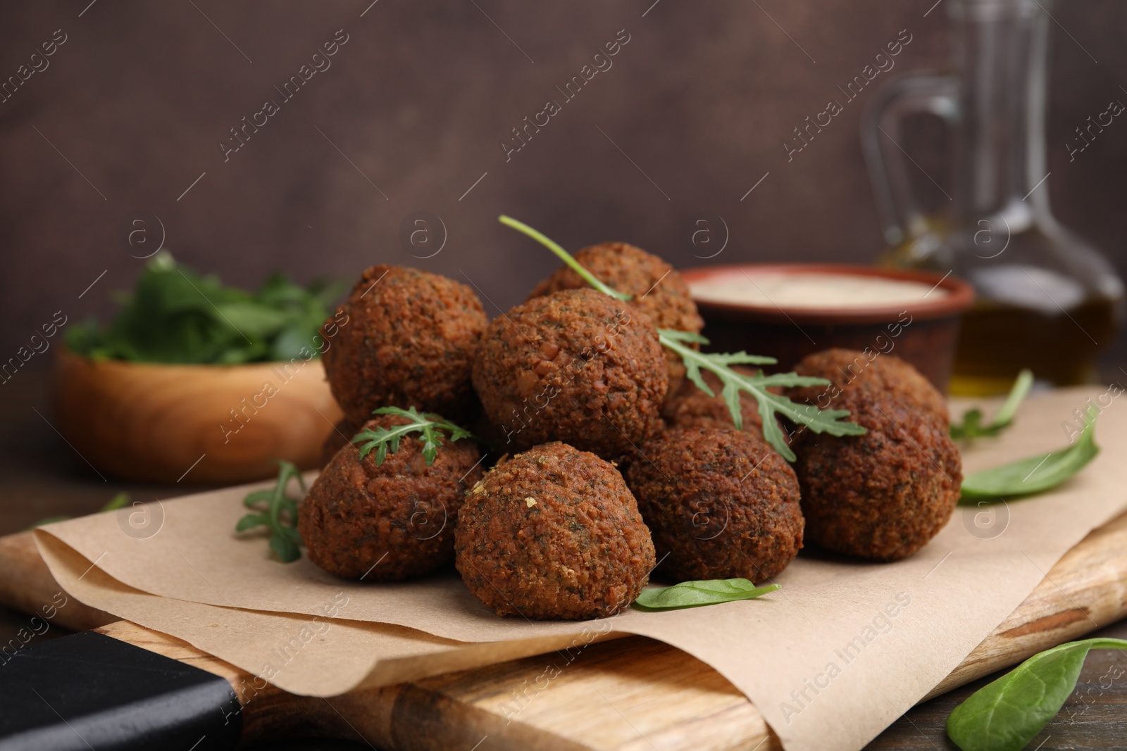 Photo of Delicious falafel balls and arugula on table