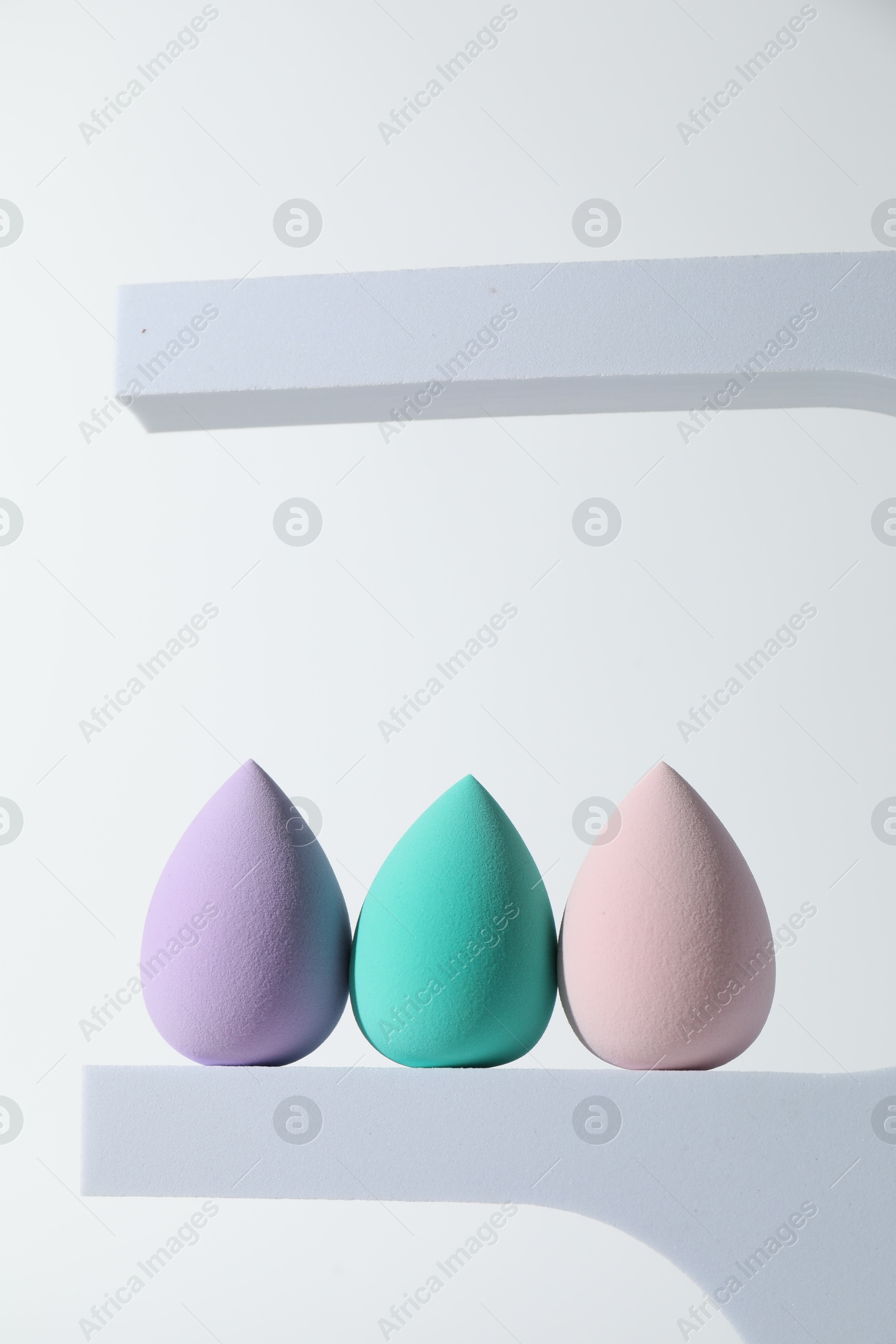 Photo of Stylish presentation of makeup sponges on white background