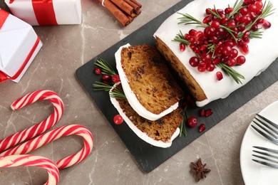 Flat lay composition with traditional classic Christmas cake with cranberries, pomegranate seeds and rosemary on table