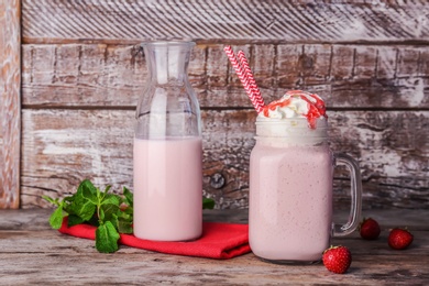 Photo of Glassware with delicious milk shake on table