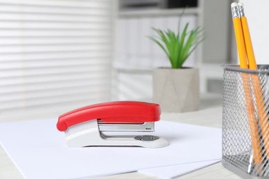 Bright stapler and papers on table indoors