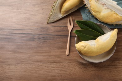 Photo of Fresh ripe durians on wooden table, flat lay. Space for text