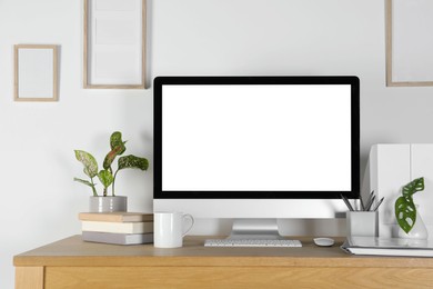 Photo of Home workplace. Computer, stationery and houseplants on wooden desk