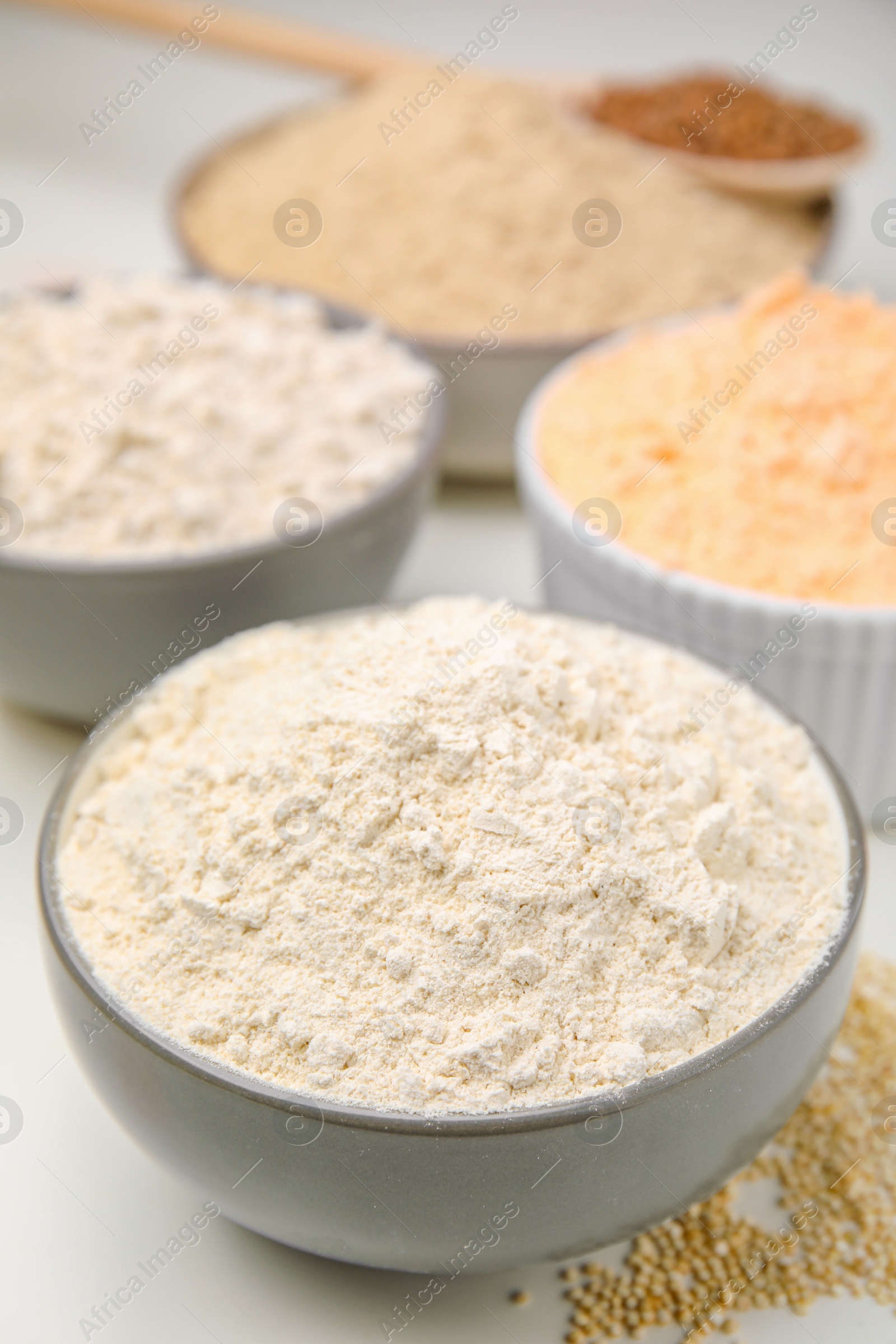 Photo of Different types of flour on white table, closeup