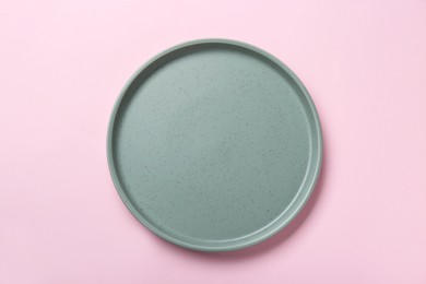Photo of Empty grey ceramic plate on pink background, top view