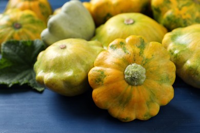 Fresh ripe pattypan squashes on blue wooden table, closeup