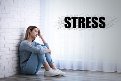 Depressed young girl sitting on floor indoors and word STRESS