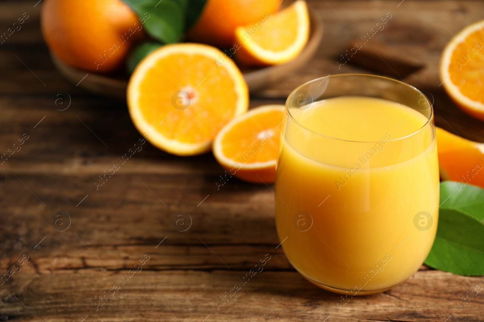 Photo of Glass of orange juice and fresh fruits on wooden table