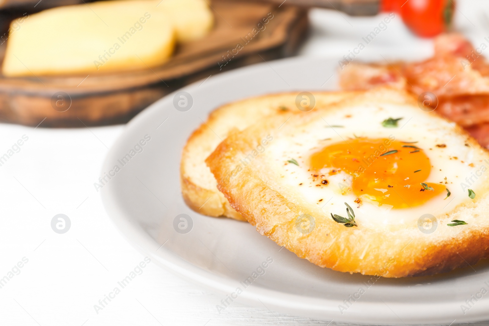 Photo of Plate with fried egg, bacon and toasts on table, closeup