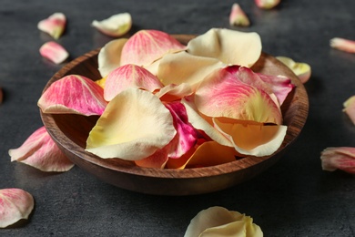 Plate with rose petals on grey background, closeup