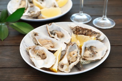 Photo of Fresh oysters with cut juicy lemon served on table