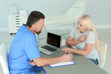 Male medical assistant consulting female patient in clinic