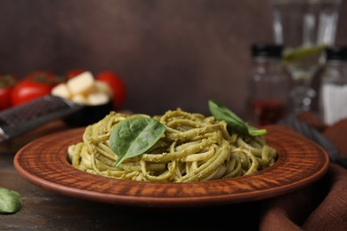 Tasty pasta with spinach on wooden table, closeup