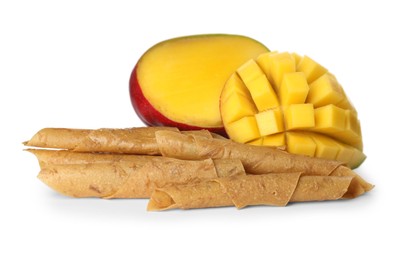 Photo of Delicious fruit leather rolls and mango on white background