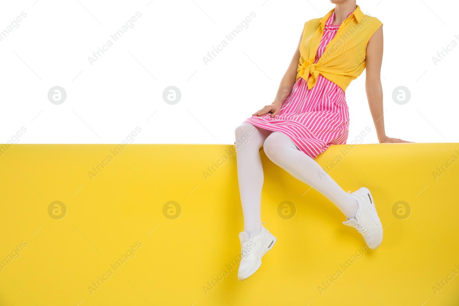 Photo of Woman wearing white tights sitting on color background, closeup. Space for text
