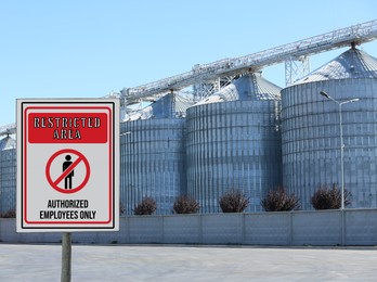 Sign with text Restricted Area Authorized Employees Only near granaries outdoors