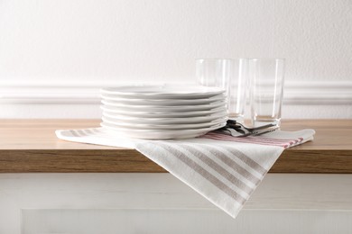 Photo of Kitchen towel and clean dishware on wooden countertop