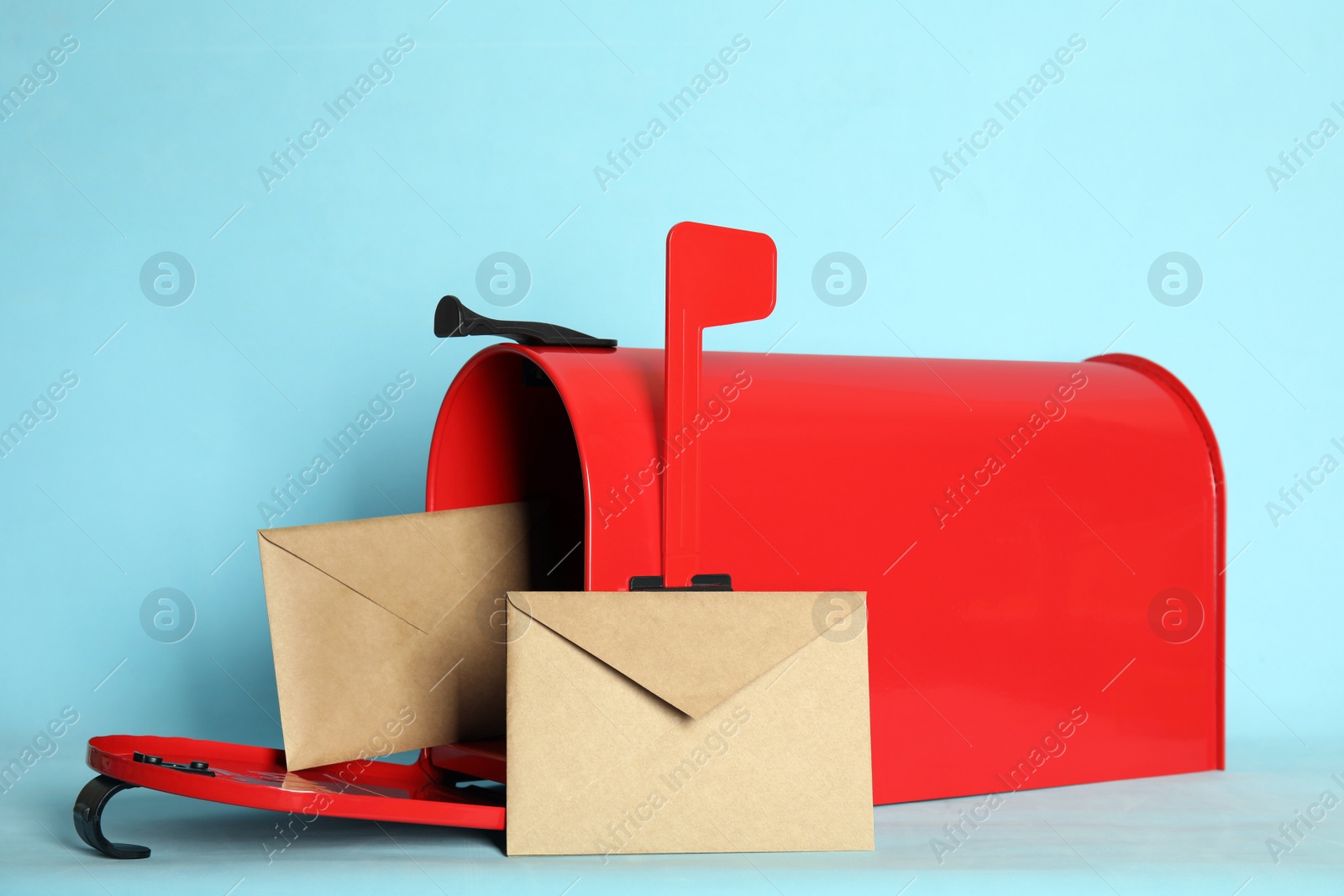 Photo of Open red letter box with envelopes on turquoise background