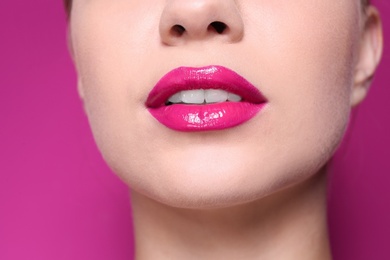 Photo of Beautiful young woman with perfect lips makeup on color background, closeup