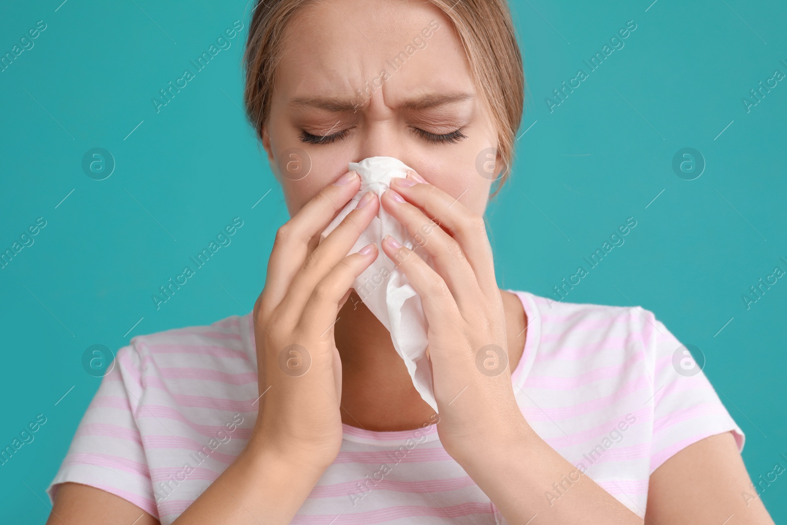 Photo of Young woman suffering from allergy on turquoise background