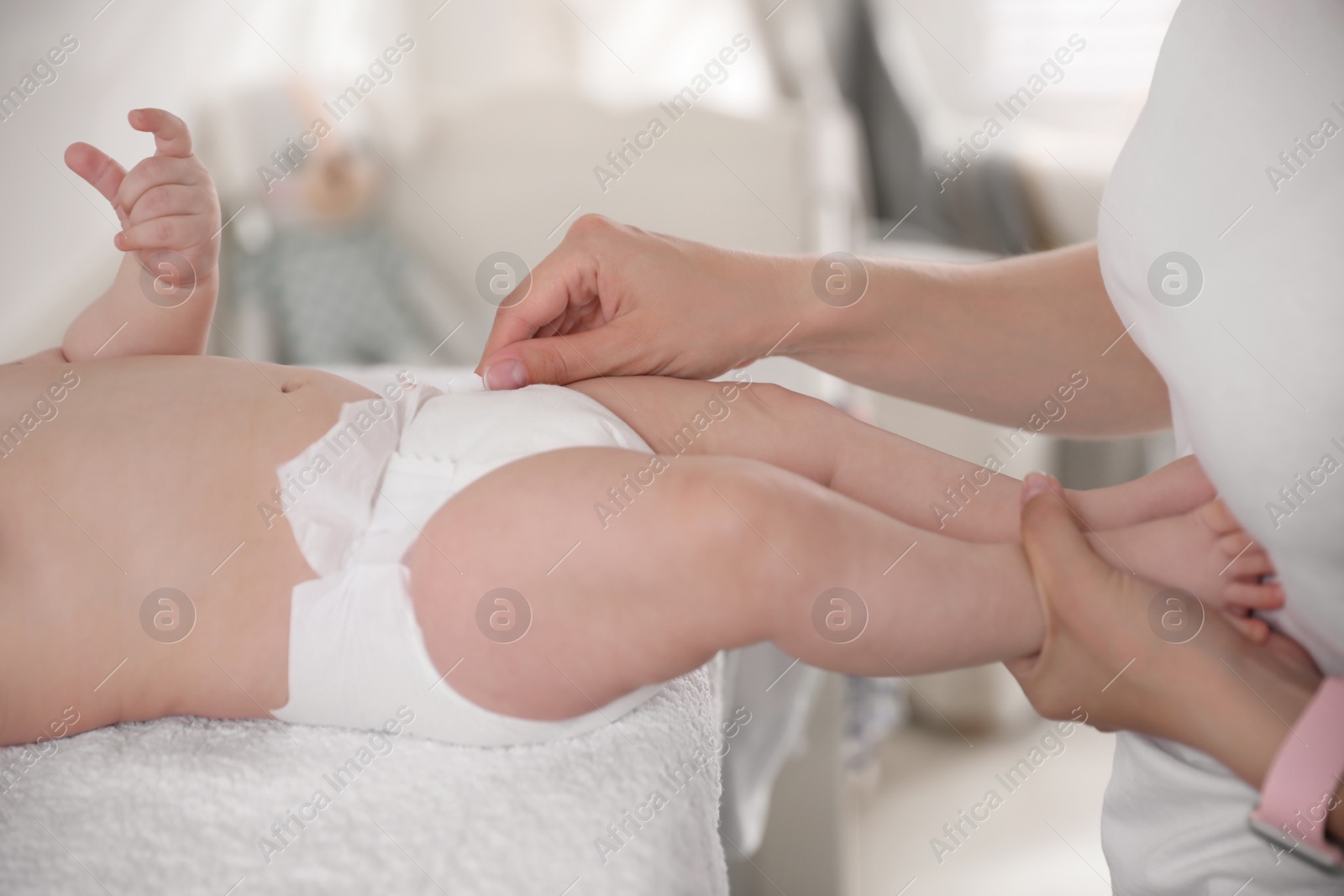 Photo of Mother changing baby's diaper on table, closeup