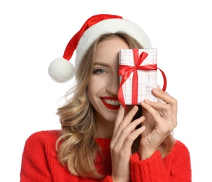 Happy young woman wearing Santa hat with Christmas gift on white background