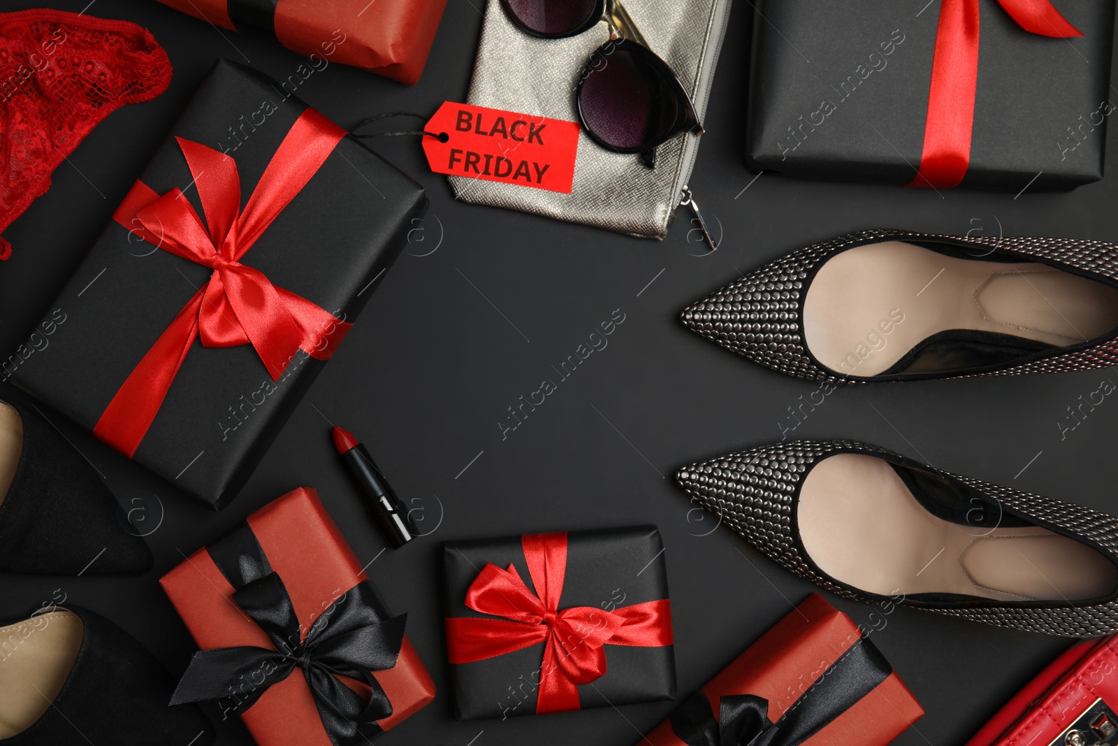 Photo of Gift boxes, cosmetics, shoes, stylish women's accessories and space for text on dark background, flat lay. Black Friday sale