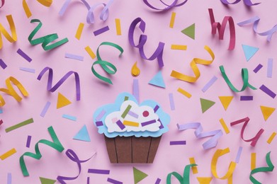 Birthday party. Paper cupcake and confetti on pink background, flat lay