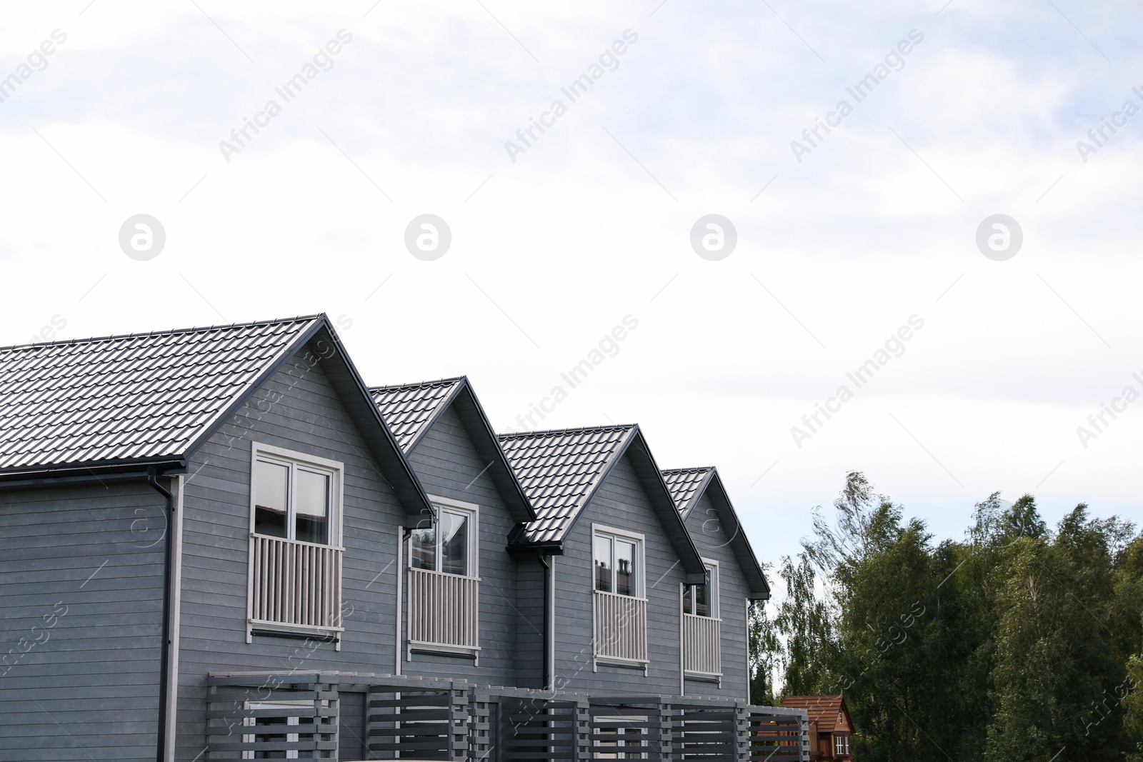 Photo of Beautiful modern grey houses against cloudy sky