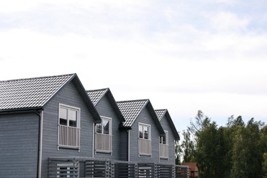 Beautiful modern grey houses against cloudy sky